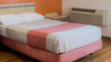 A single bed with a wooden frame, a headboard, and a bedside table.