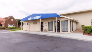 A building with a 'welcome' sign, a covered entrance, and a number '853' on the door. - Travelodge by Wyndham Norfolk Airport (Norfolk)