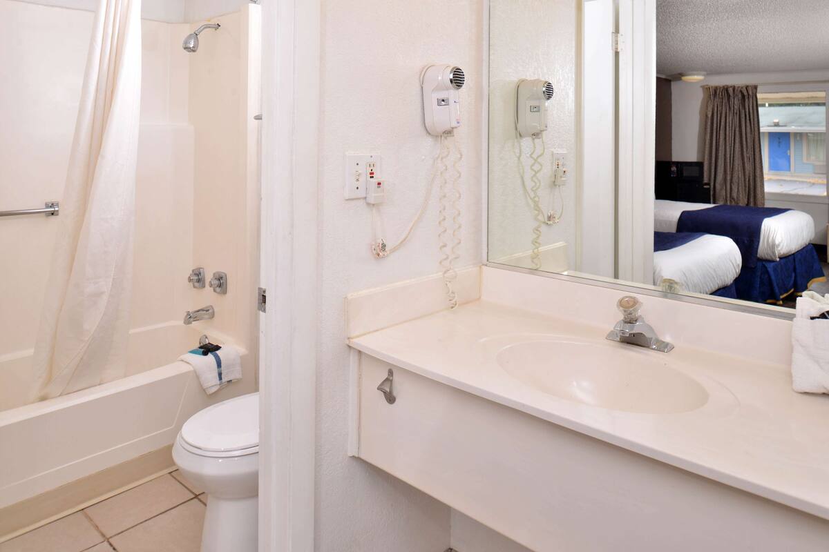 Ein Badezimmer mit Badewanne, Toilette und Waschbecken mit Spiegel.