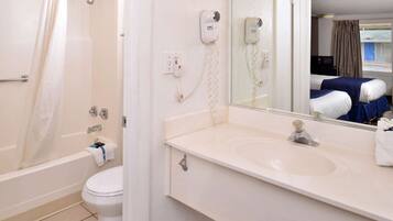 A bathroom with a bathtub, toilet, and a sink with a mirror.
