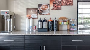 Une cuisine moderne équipée d’une machine à café, d’une machine à expresso et d’un espace dédié à la préparation du café.