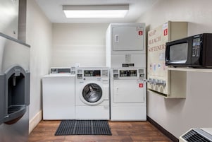 Una sala de lavandería con lavadora, secadora y microondas.