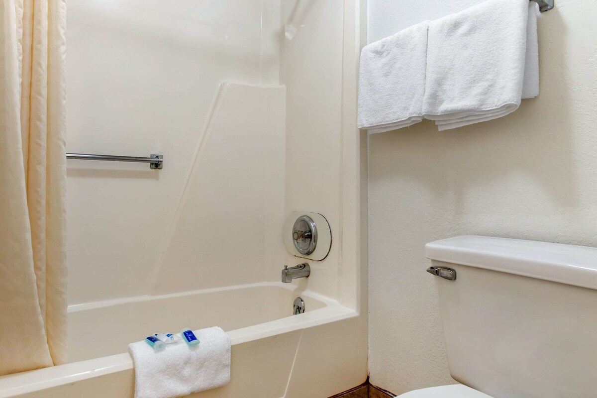 A bathroom with a bathtub, a toilet, and a towel rack.