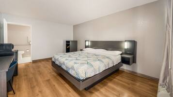 A bedroom with a bed, bedside tables, a desk, and a chair.