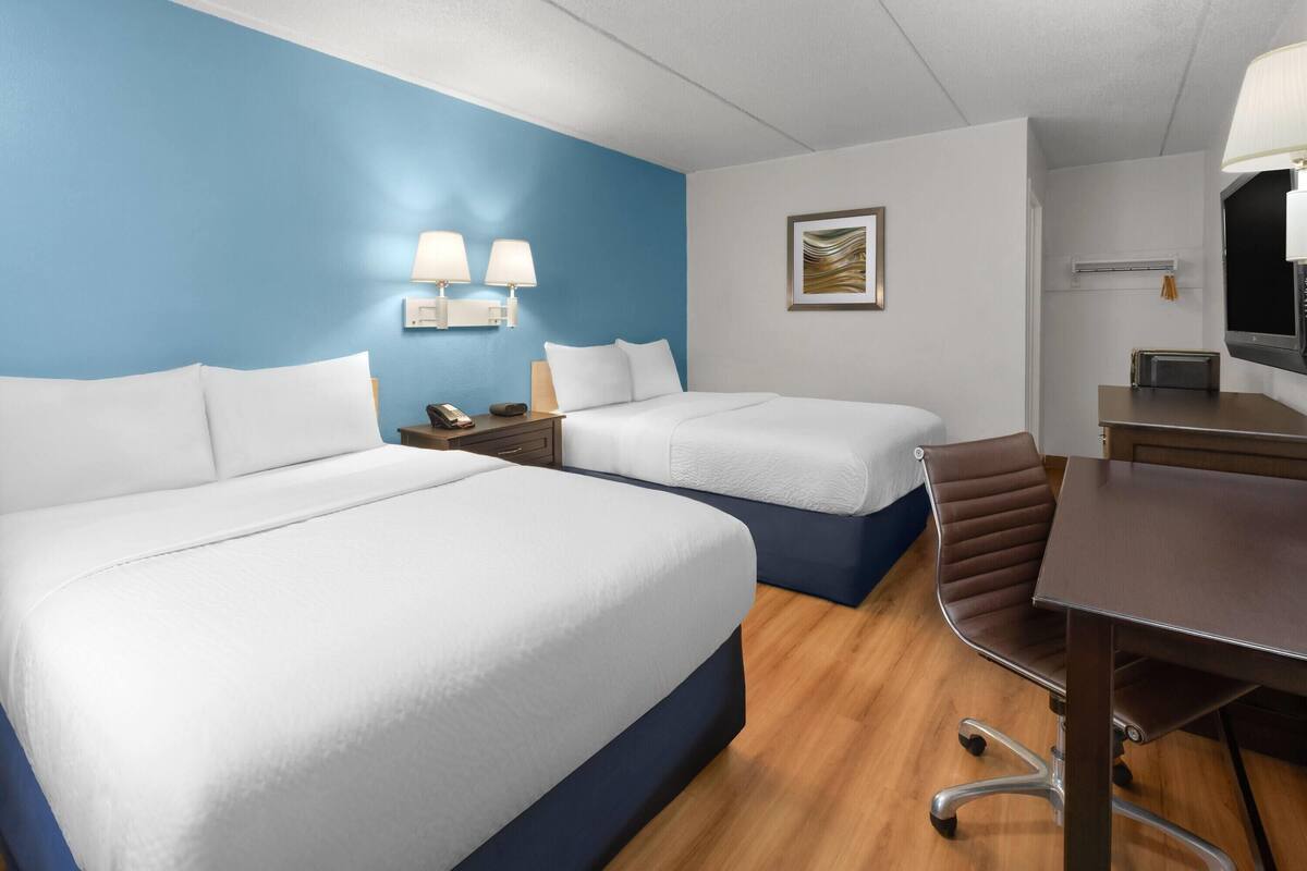 Una habitación de hotel con dos camas, un escritorio y una silla.