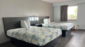A hotel room with two beds, a nightstand, a desk, a window with curtains, and a ceiling fan. - Motel 6 Middleburg Heights, OH - Cleveland (Middleburg Heights)