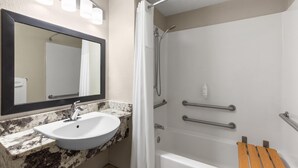 A bathroom with a sink, mirror, shower, and grab bars. - Days Inn by Wyndham Charleston WV (Charleston)
