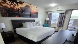 A hotel room with a large bed, a desk, and a view of the outdoors. - Days Inn by Wyndham Charleston WV (Charleston)