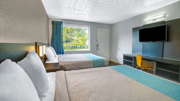 Une chambre d’hôtel avec deux lits, une télévision, un bureau et une fenêtre avec des rideaux.