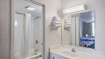 Une salle de bain équipée d’une douche, de toilettes, d’un lavabo et d’un grand miroir.