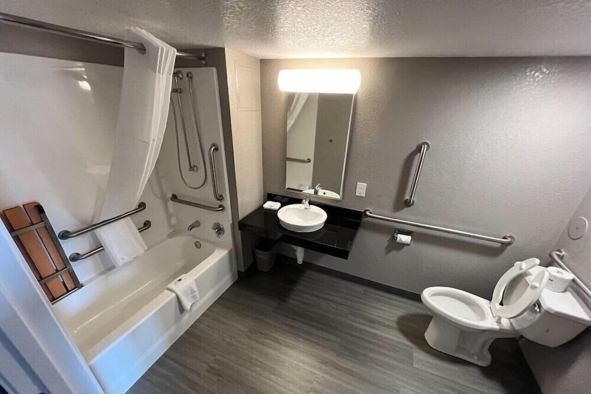 A modern bathroom with a bathtub, a sink, and a toilet.