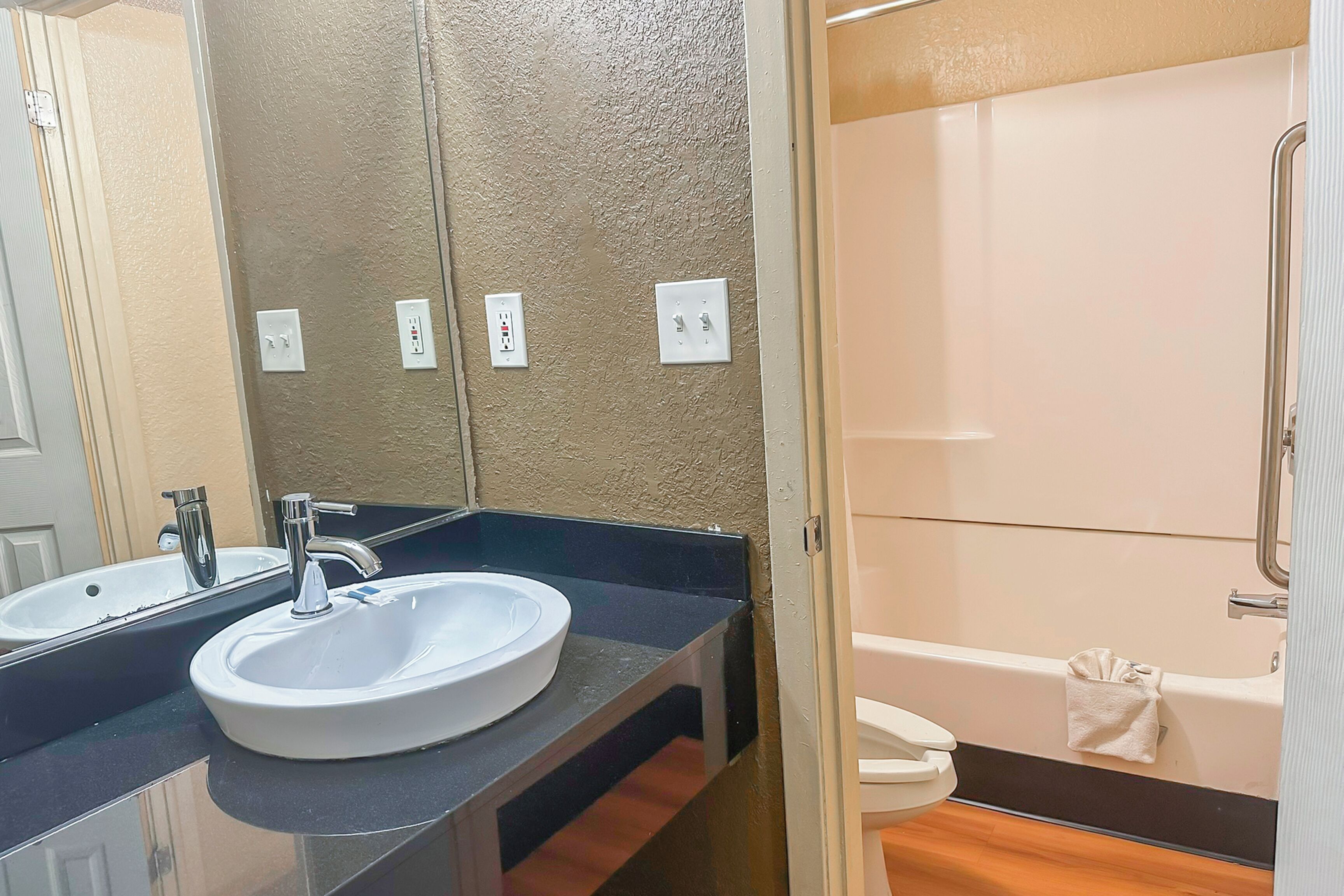 Un baño con lavamanos, espejo e inodoro.