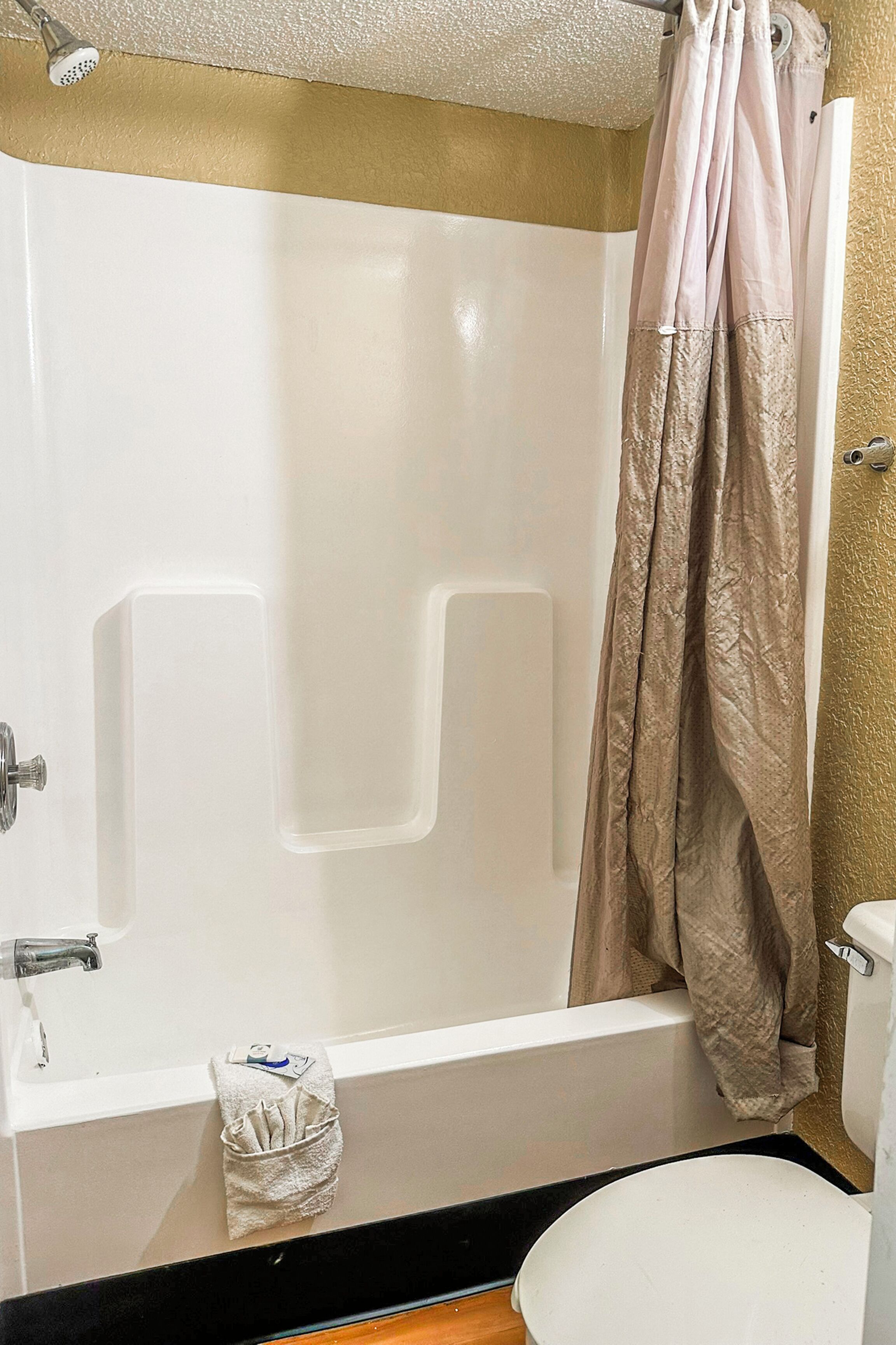 Une salle de bain avec une baignoire, des toilettes et un rideau de douche.