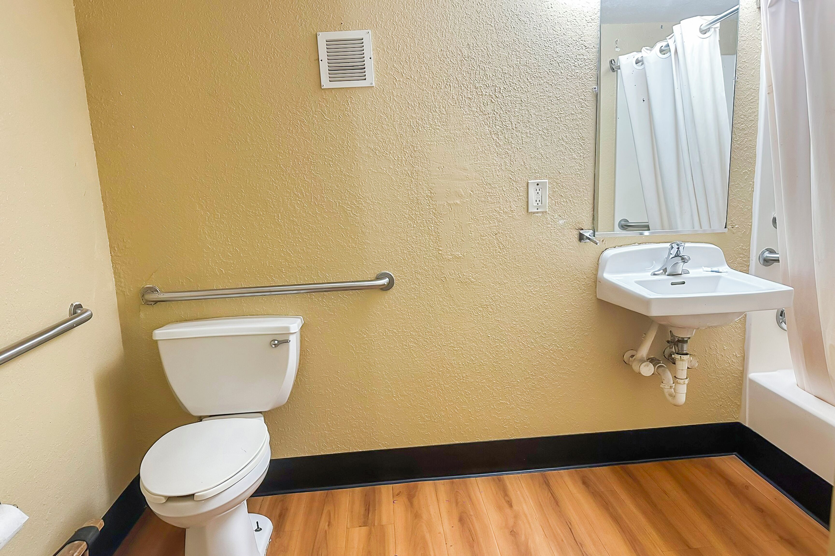 Une salle de bain comprenant des toilettes, un lavabo et un espace douche.