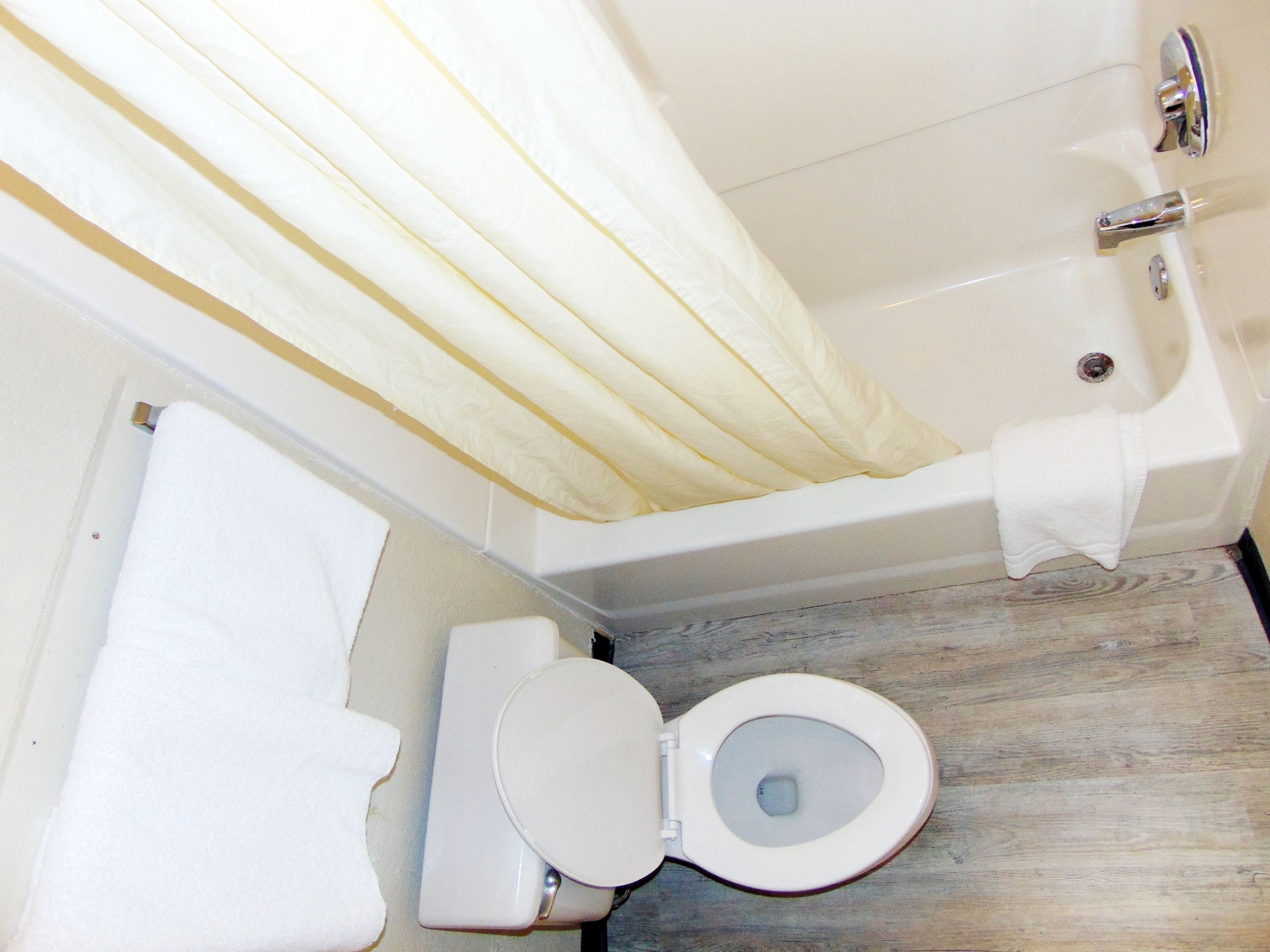 Kylpyhuone, jossa on kylpyamme, wc ja suihkuverho.