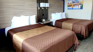 A hotel room with two beds, a nightstand with a lamp, and a painting on the wall. - Somatel Nashville Airport Hotel (Nashville)