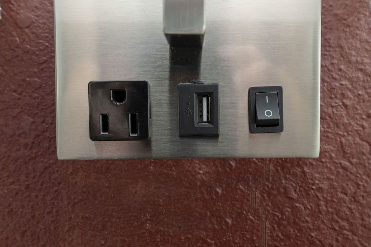 A metallic switchboard with three electrical outlets and a power socket.