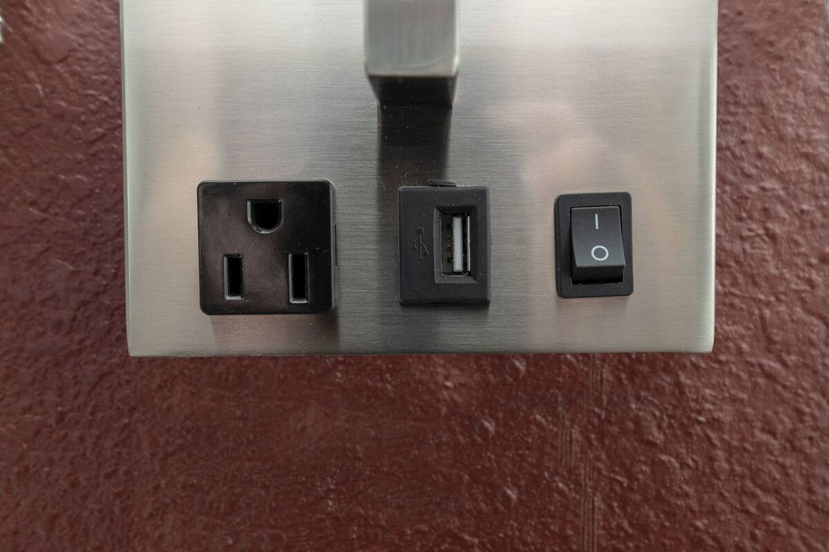 A metallic switchboard with three electrical outlets and a power socket.