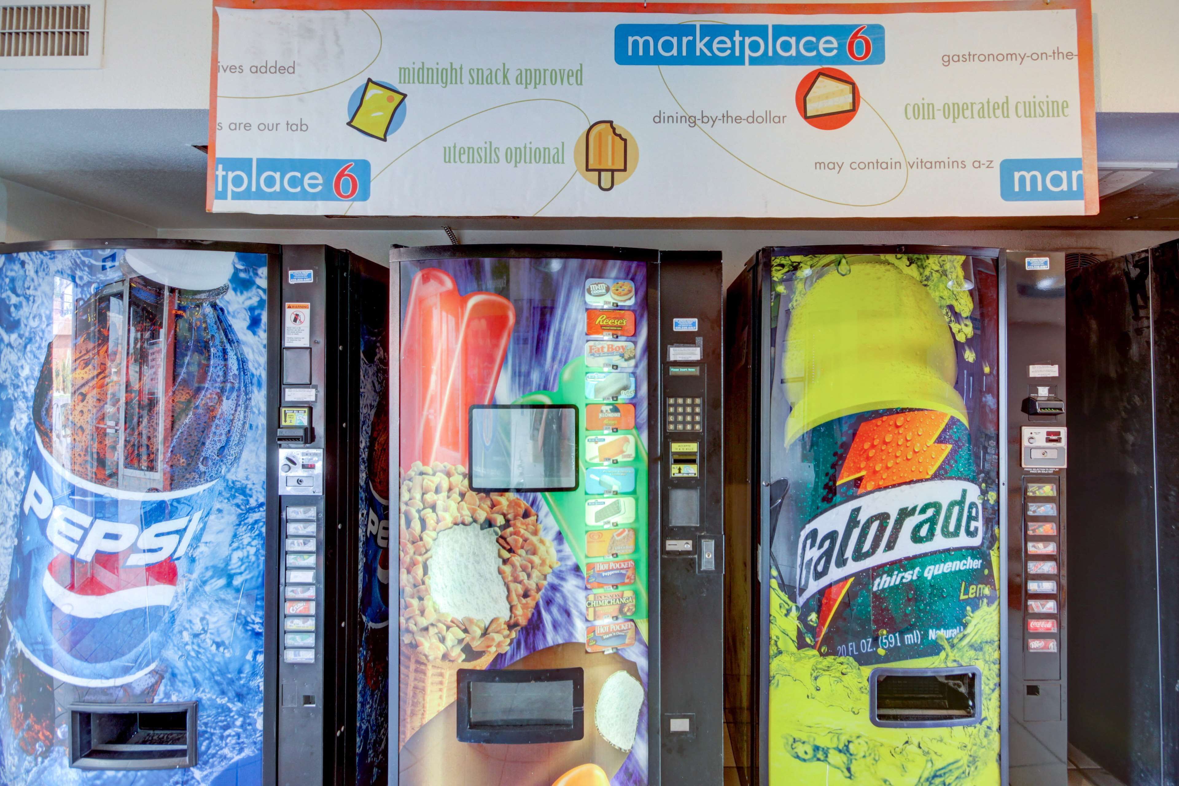Una hilera de máquinas expendedoras de bebidas con las marcas Pepsi, Hershey’s y Gatorade.