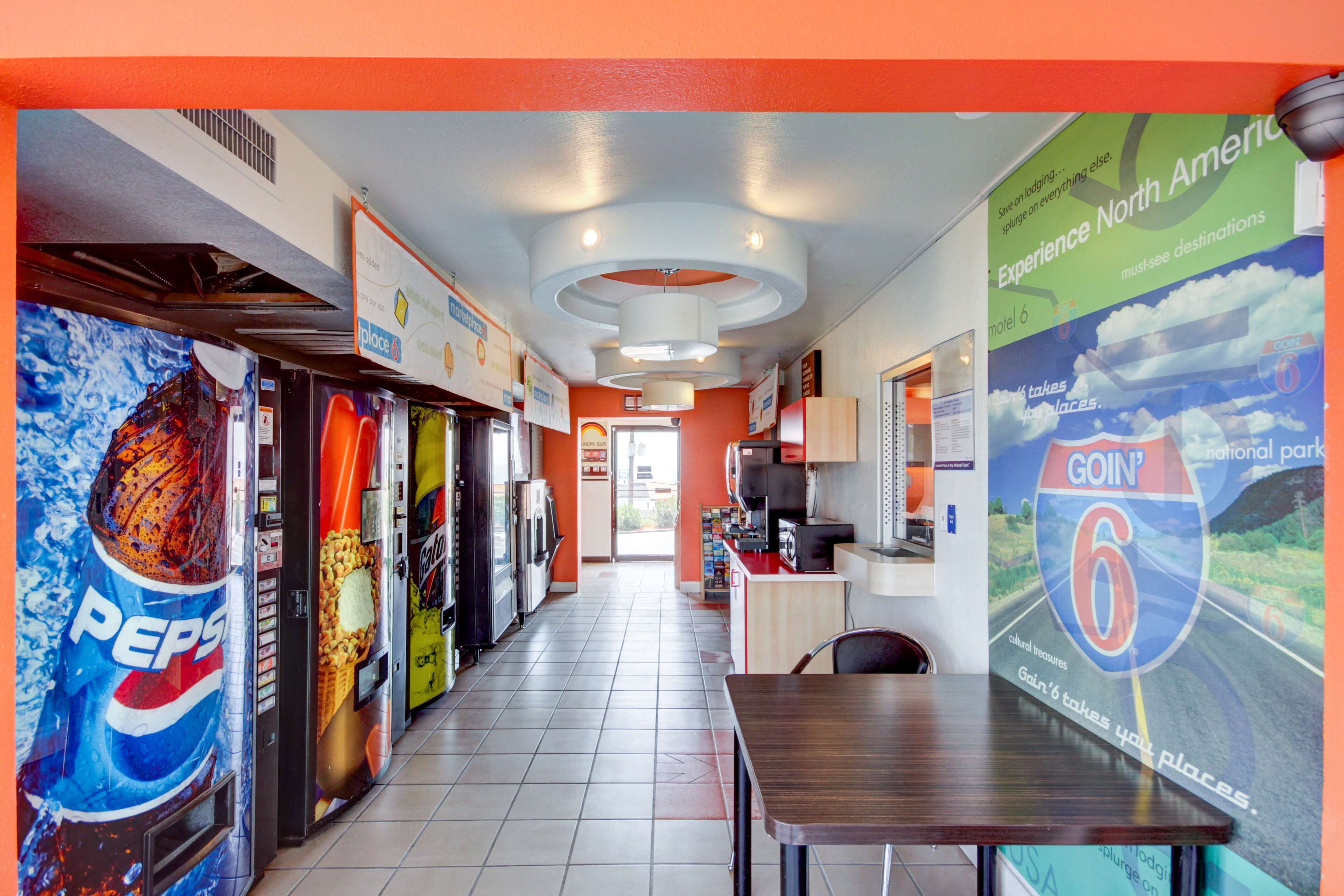 A corridor with vending machines, a table, and a wall with a 'Goin' 6' sign.