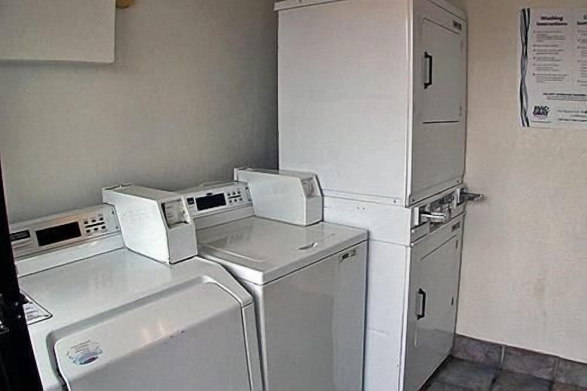 Une buanderie équipée d’un lave-linge, d’un sèche-linge et d’armoires superposées.
