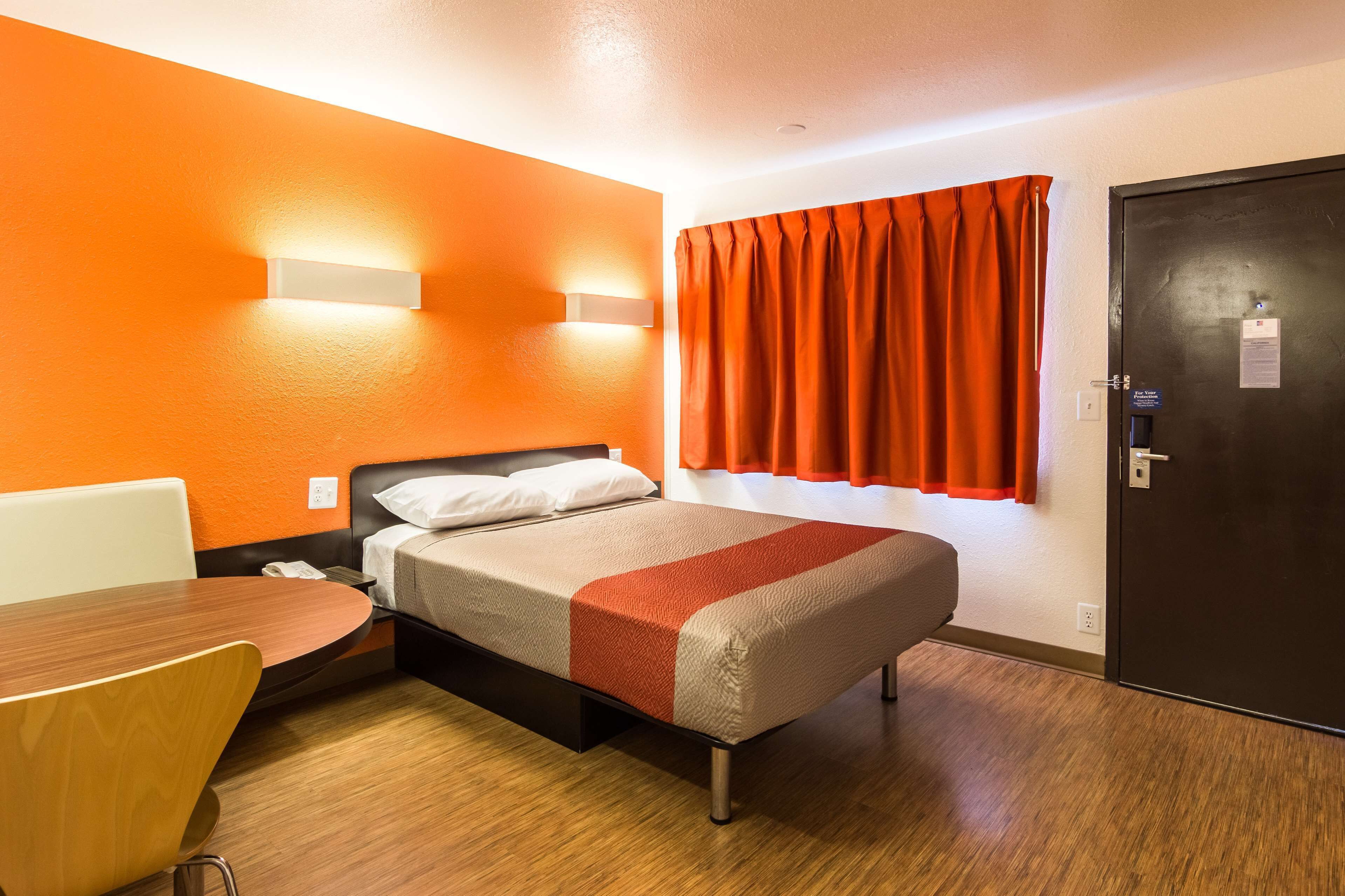 A hotel room with a bed, a desk, and a chair.