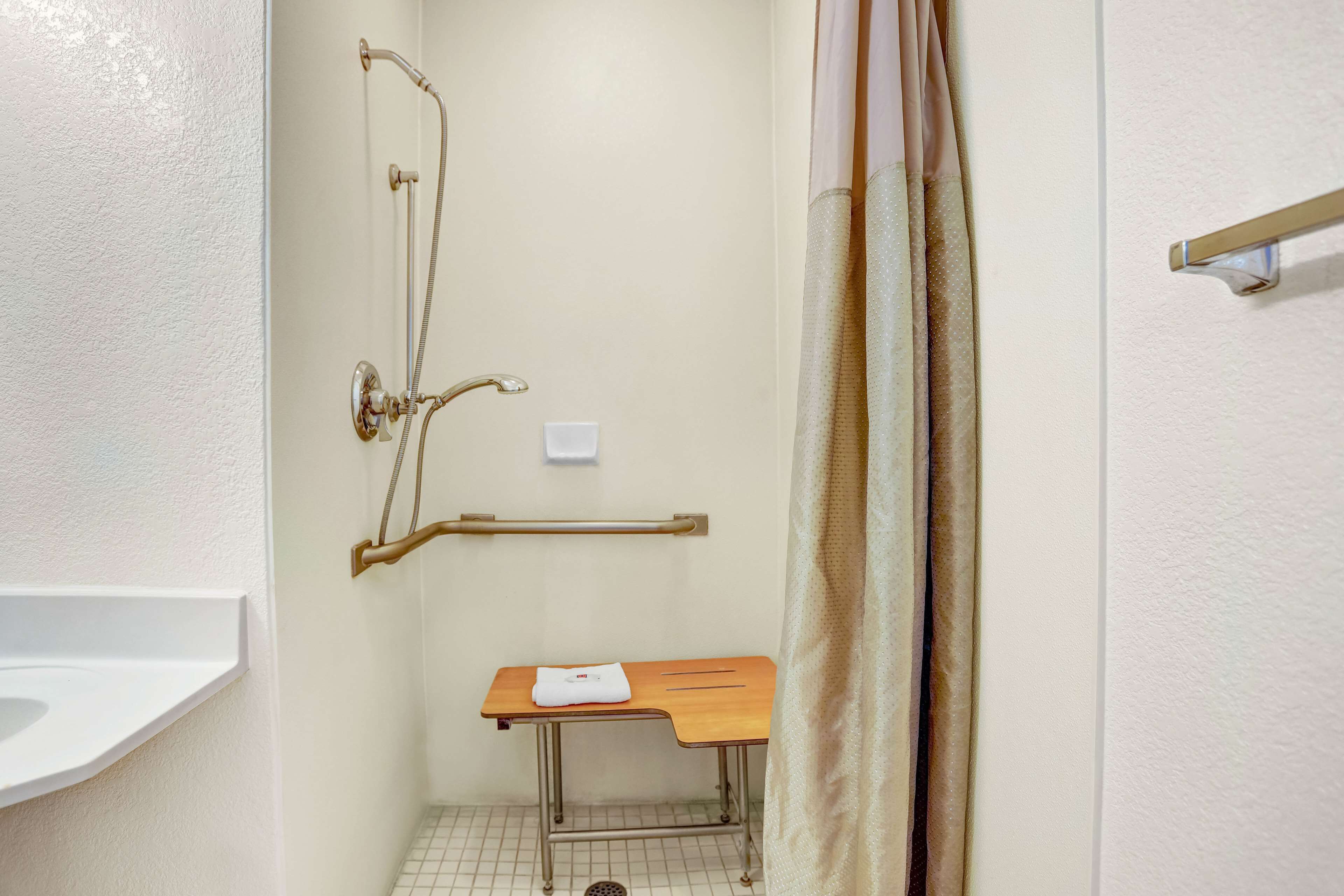 A small, private bathroom with a shower, a toilet, and a sink.