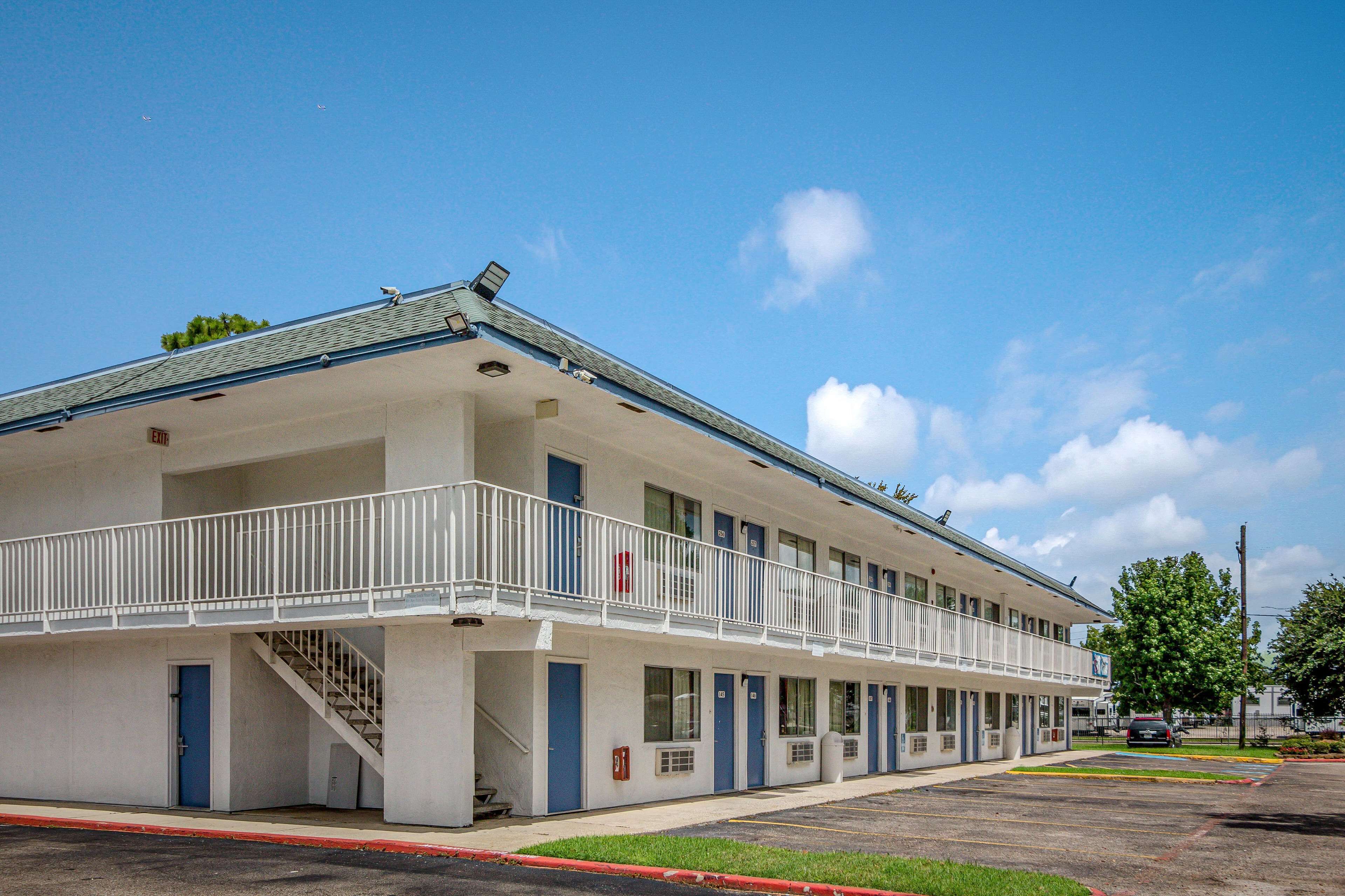 A motel with a two-story structure, a covered walkway, and a parking lot.