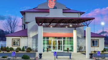 Un hôtel Red Roof Inn doté d’une entrée abritée, de places de stationnement réservées aux personnes handicapées et d’un parking.