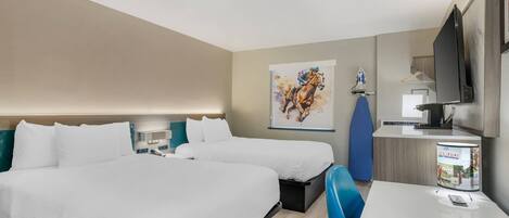 Habitación de hotel con dos camas, un escritorio, un televisor y un cuadro en la pared.
