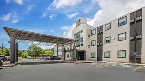 A modern hotel with a covered entrance, parking lot, and clear signage. - Quality Inn Ruidoso (Ruidoso)