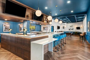 Une cuisine moderne avec un îlot central, des tabourets de bar et une table de billard.