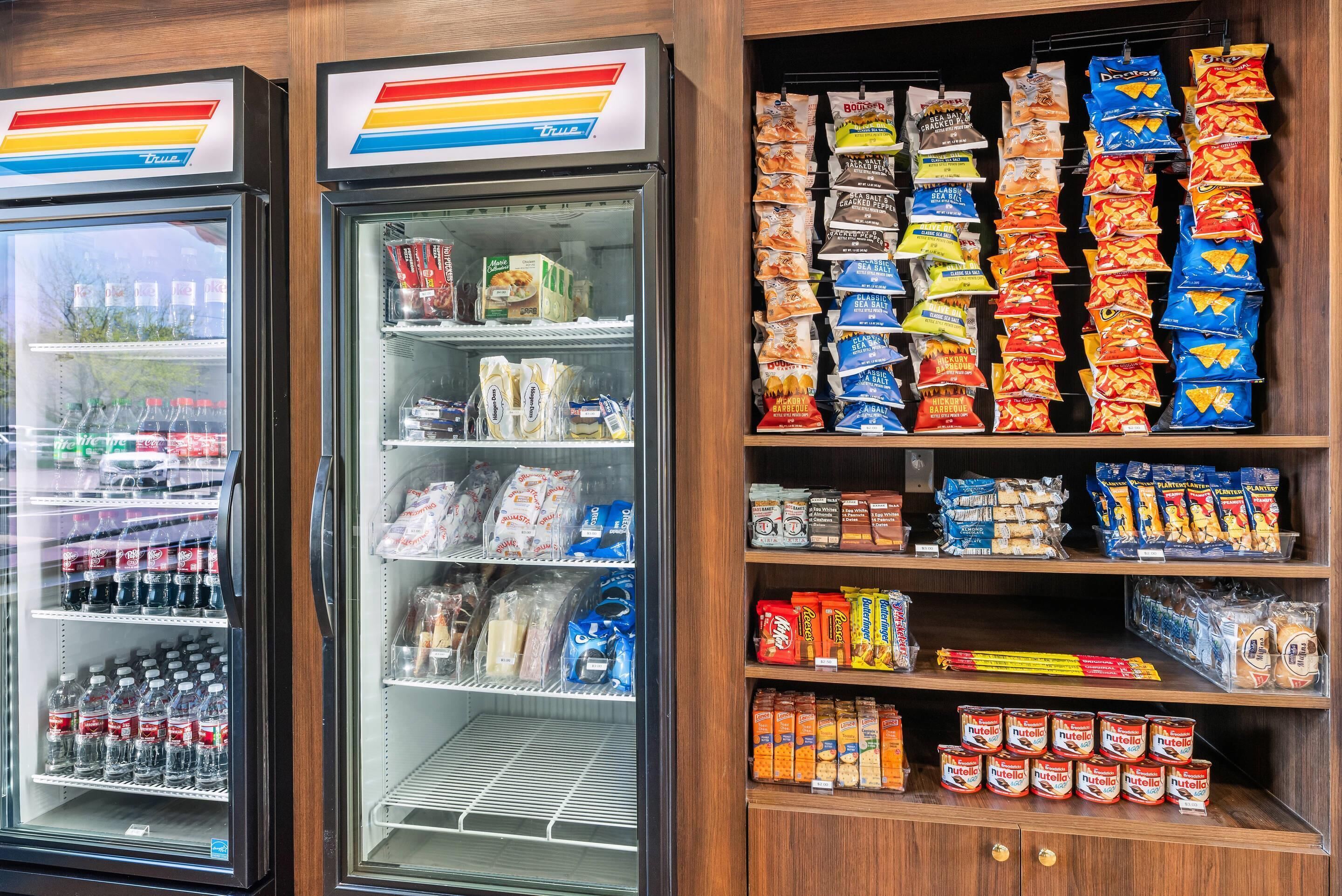 Un expositor refrigerado con diferentes aperitivos y bebidas.