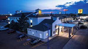 A hotel with a parking lot, a gas station, and a Days Inn sign. - Super 8 by Wyndham Sidney NE I-80 (Sidney)