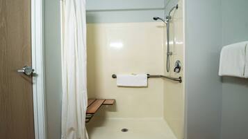 Un baño con ducha, un perchero y un banco de madera.