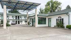 A motel with a covered parking area, a green door, and a sign indicating room number 2735. - Motel 6 Albany, OR (Albany)