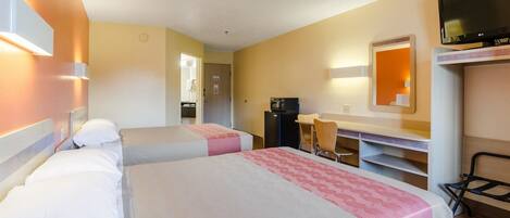 A hotel room with two beds, a desk, a TV, and a mirror.