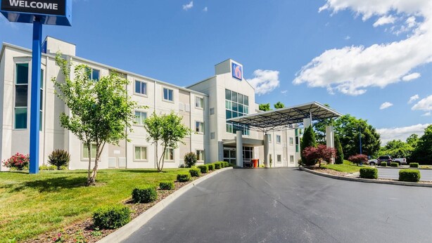 A modern hotel with a clear entrance, a covered parking area, and a well-maintained lawn. - Motel 6 Bristol, VA (Bristol)