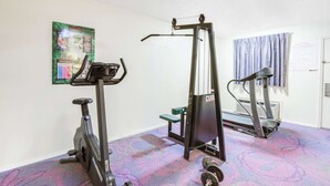 Uma academia em casa com esteira, elíptica e banco de musculação.