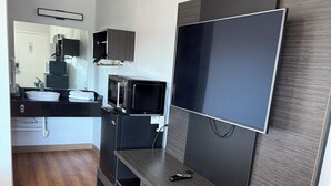 A compact kitchenette with a microwave, sink, and cabinets. - Motel 6 Gulfport, MS – Airport (Gulfport)