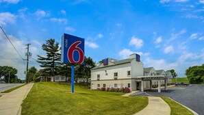 A motel with a large '6' sign, a parking lot, and a building with a covered entrance. - Motel 6 Gordonville PA - Lancaster PA (Gordonville)