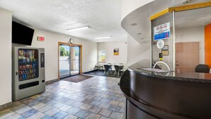 A lobby with a vending machine, a reception desk, and a door leading outside. - Motel 6 Gordonville PA - Lancaster PA (Gordonville)