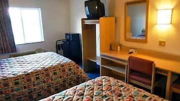 A hotel room with two beds, a desk, a chair, a television, and a mirror.