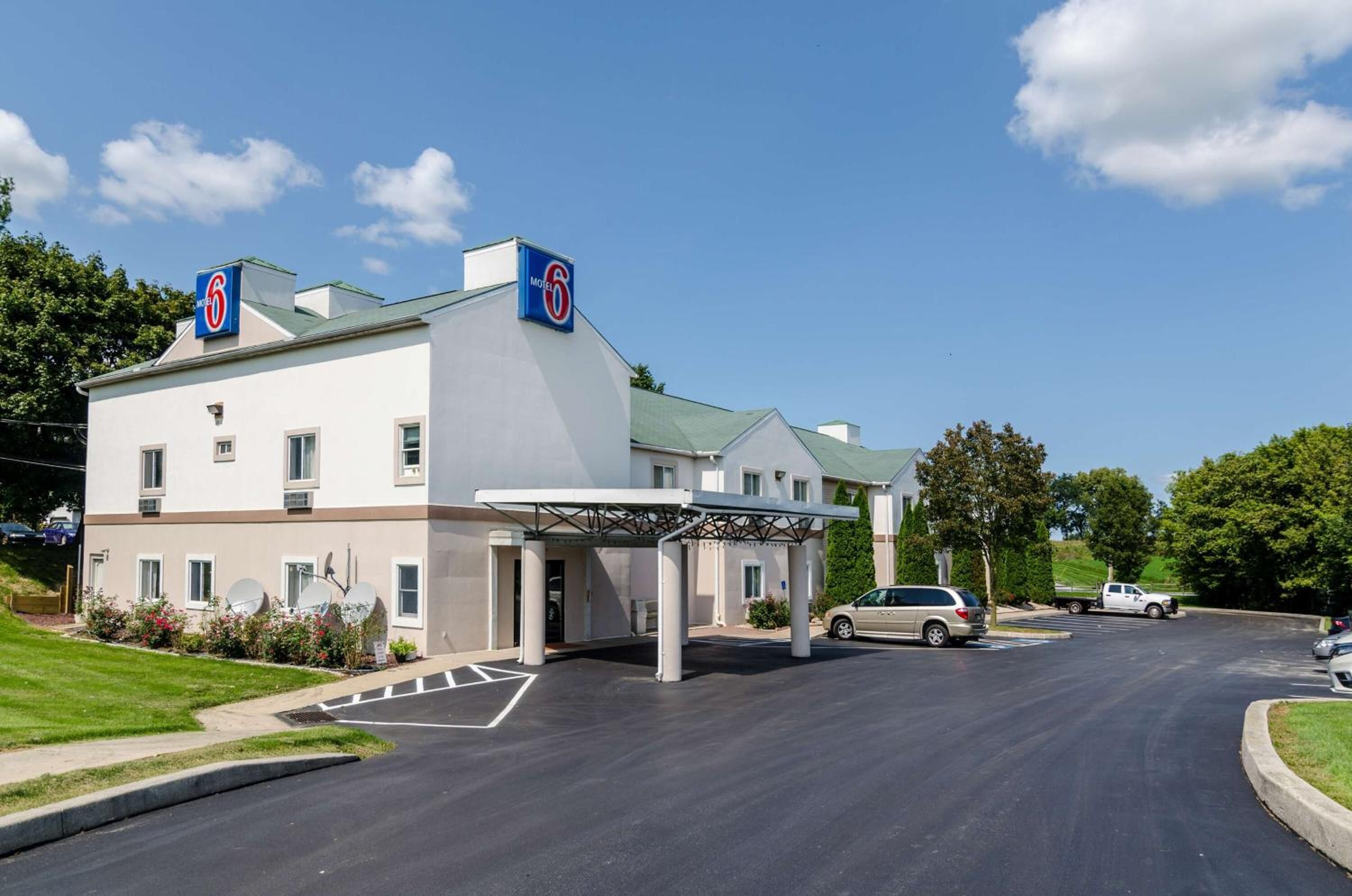 Un hotel de 6 estrellas con entrada cubierta, antenas parabólicas y aparcamiento.