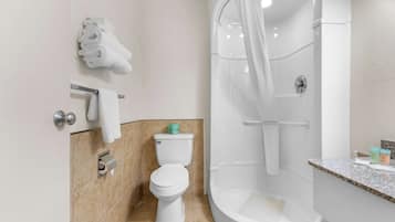 A modern bathroom with a toilet, shower, and sink.
