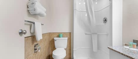 A modern bathroom with a toilet, shower, and sink.