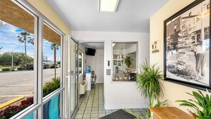 Un vestíbulo de hotel con vistas a la calle, una mesa de recepción y un mapa grande en la pared.