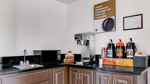 A kitchen with a coffee machine, tea boxes, and a coffee station. - Motel 6 Beaver, UT (Beaver)