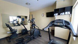 A gym with treadmills, elliptical machines, and a stationary bike. - Days Inn & Suites by Wyndham Augusta Near Fort Eisenhower (Grovetown)