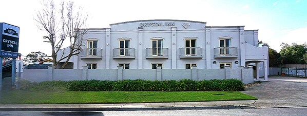 Un edificio con un letrero que dice 'CRYSTAL INN' y una entrada con portones.